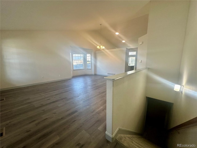 additional living space featuring high vaulted ceiling, dark hardwood / wood-style flooring, and a notable chandelier