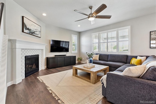 8102 Adams Fork Ave, Littleton, CO 80125 - living area with ceiling fan, dark wood-style floors, recessed lighting, a tile fireplace, and baseboards