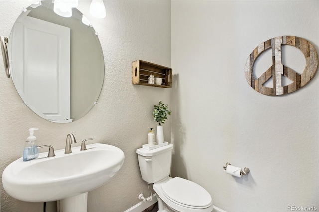 8102 Adams Fork Ave, Littleton, CO 80125 - bathroom featuring baseboards, toilet, and a sink