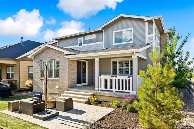 8102 Adams Fork Ave, Littleton, CO 80125 - view of front facade with covered porch, an outdoor living space, and brick siding