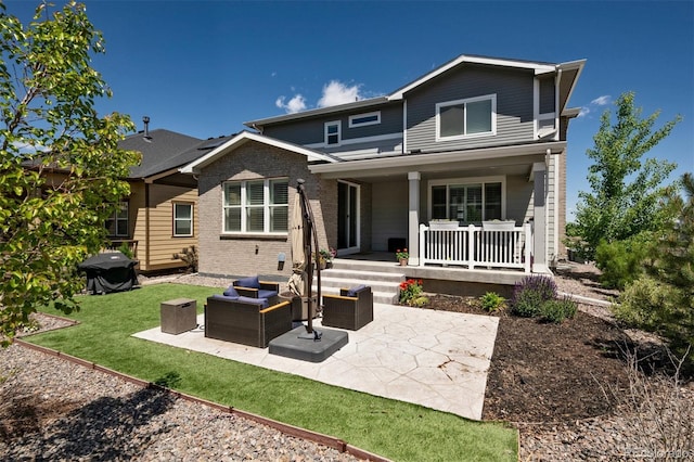 8102 Adams Fork Ave, Littleton, CO 80125 - back of house featuring brick siding, a porch, an outdoor hangout area, a patio, and a lawn
