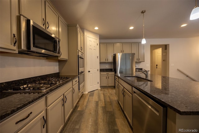 kitchen featuring appliances with stainless steel finishes, a sink, dark wood-type flooring, recessed lighting, and pendant lighting