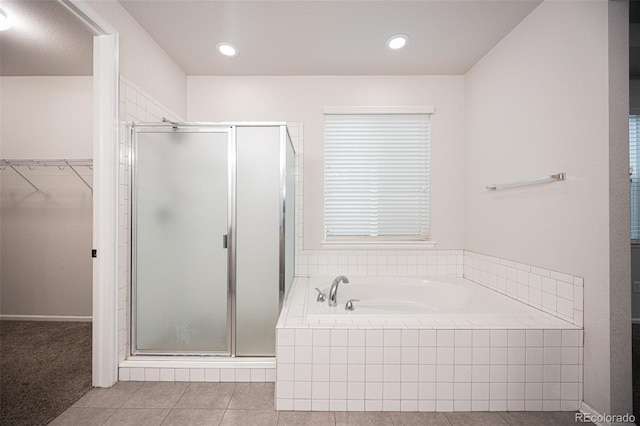 bathroom with a spacious closet, a shower stall, tile patterned flooring, a bath, and recessed lighting