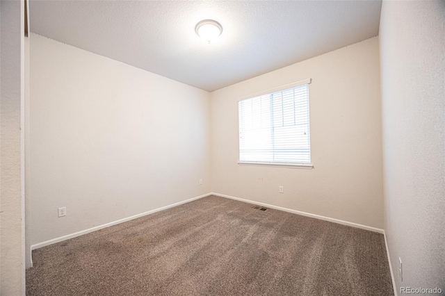 carpeted empty room with baseboards