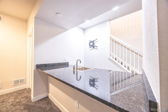 bar featuring a sink, carpet floors, baseboards, and stairs