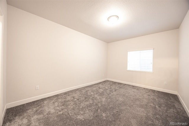 carpeted empty room featuring baseboards and a textured ceiling