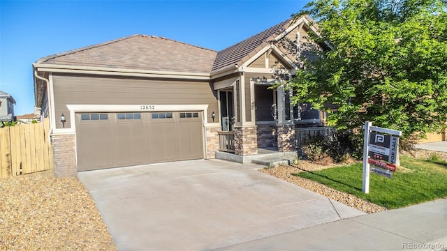 12652 Glencoe St, Thornton, CO 80241 - craftsman-style home featuring stone siding, a garage, driveway, fence, and covered porch