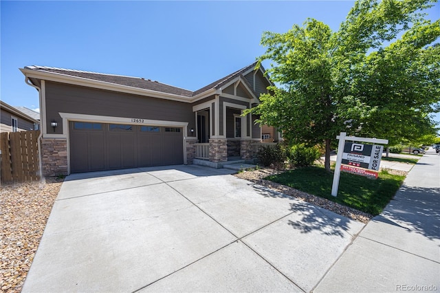 12652 Glencoe St, Thornton, CO 80241 - view of front facade with stone siding, a garage, concrete driveway, and fence