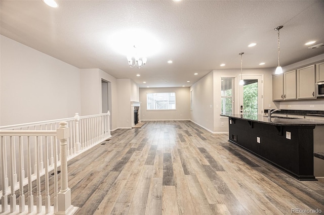 12652 Glencoe St, Thornton, CO 80241 - kitchen featuring stainless steel microwave, light wood-type flooring, open floor plan, healthy amount of natural light, and recessed lighting