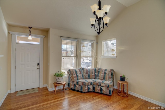 entrance foyer featuring baseboards, an inviting chandelier, and wood finished floors