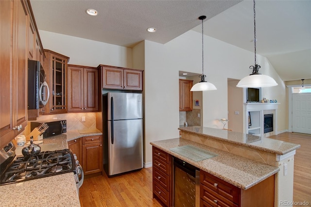 kitchen with beverage cooler, light wood finished floors, stainless steel appliances, and vaulted ceiling