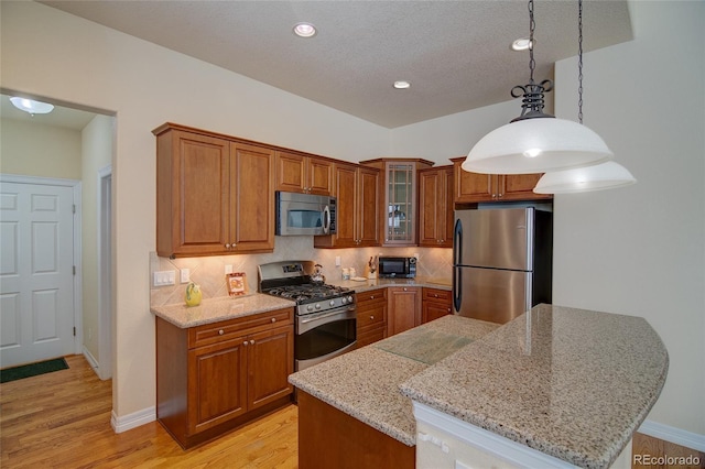 kitchen featuring brown cabinetry, backsplash, light wood finished floors, and stainless steel appliances