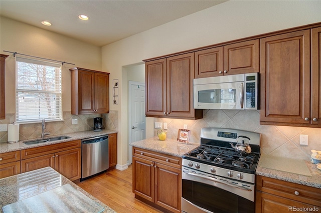 kitchen featuring a sink, stainless steel appliances, and brown cabinetry