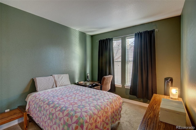 carpeted bedroom with a textured wall and baseboards