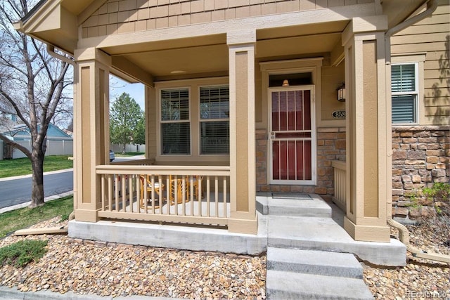 8588 W Quarles Pl, Littleton, CO 80128 - view of exterior entry featuring covered porch and stone siding
