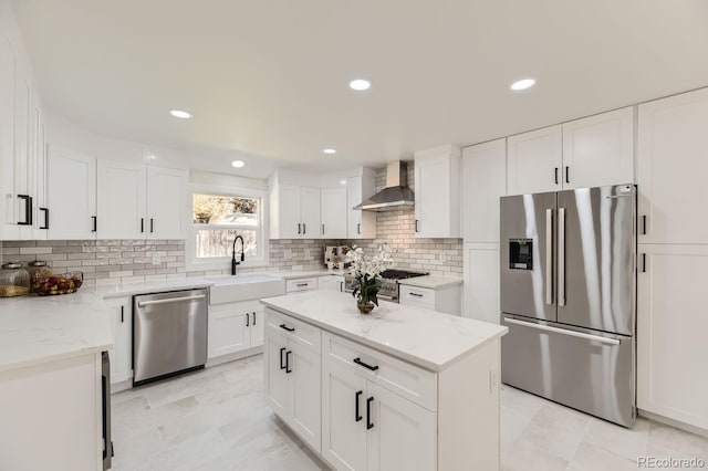 kitchen with sink, stainless steel appliances, a center island, white cabinets, and wall chimney exhaust hood