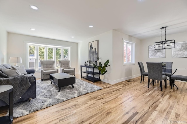 living room with an inviting chandelier and light hardwood / wood-style floors