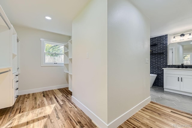 hallway with sink and light hardwood / wood-style flooring