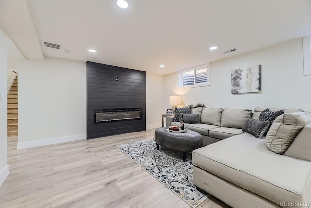 living room with a fireplace and light hardwood / wood-style flooring