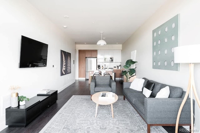 living area featuring baseboards and dark wood-style flooring