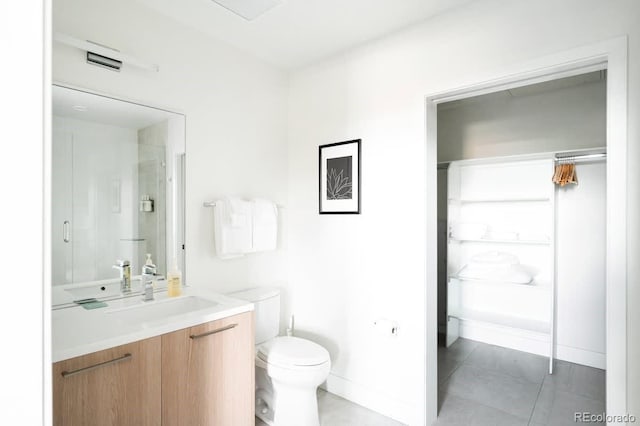 bathroom with tile patterned flooring, baseboards, vanity, and toilet