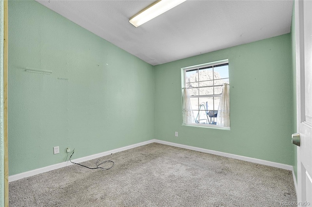 spare room with carpet floors and lofted ceiling