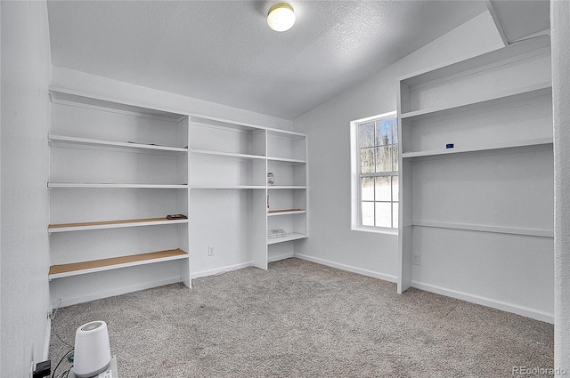 walk in closet featuring light colored carpet and lofted ceiling