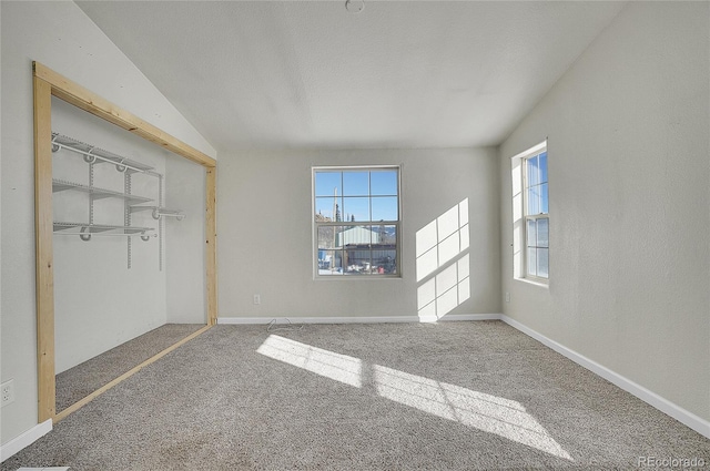 unfurnished bedroom featuring a closet, carpet floors, and lofted ceiling