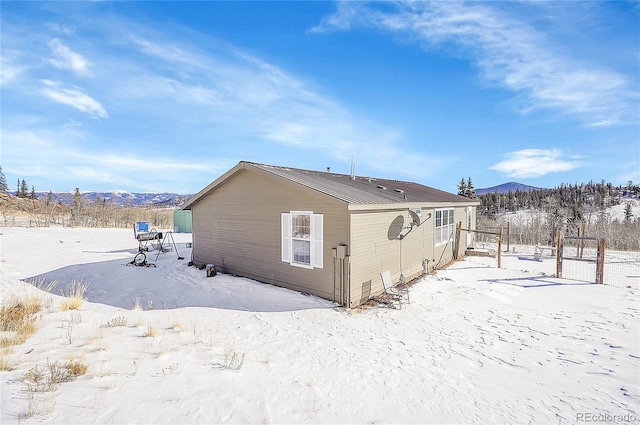 snow covered house featuring a mountain view