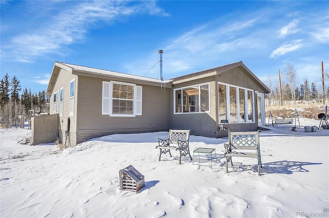 snow covered property featuring a sunroom