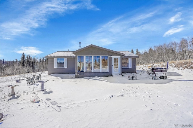 view of snow covered back of property