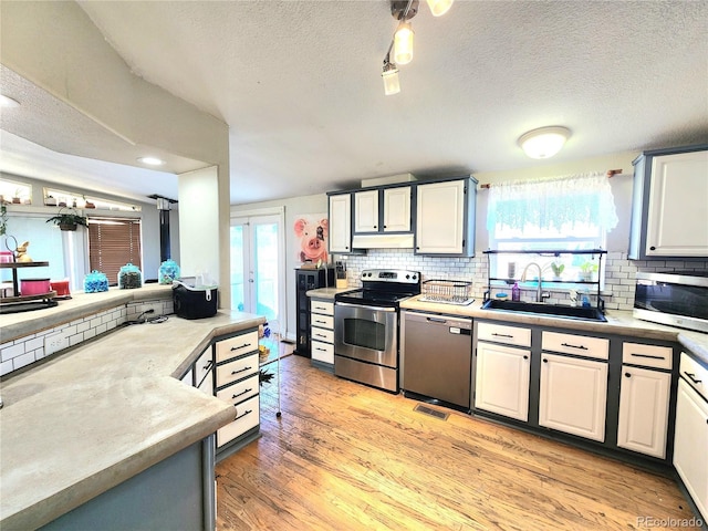 160 Shannon Ct, Rockvale, CO 81244 - kitchen with stainless steel appliances, plenty of natural light, under cabinet range hood, tasteful backsplash, and a textured ceiling