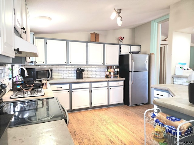 160 Shannon Ct, Rockvale, CO 81244 - kitchen featuring stainless steel appliances, vaulted ceiling, decorative backsplash, white cabinetry, and custom range hood