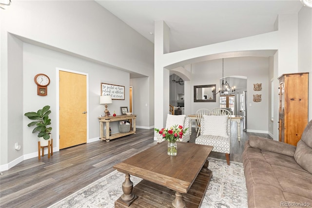 living room with wood-type flooring, high vaulted ceiling, and a chandelier