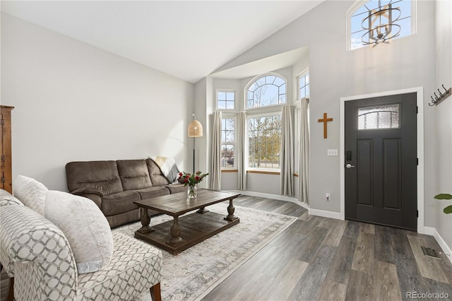 living room featuring dark wood-type flooring and high vaulted ceiling