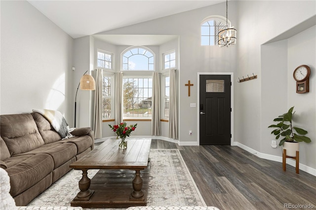 living room with a notable chandelier, a towering ceiling, and dark wood-type flooring