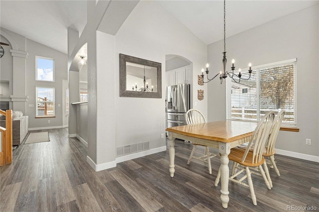 dining area with dark hardwood / wood-style floors and high vaulted ceiling