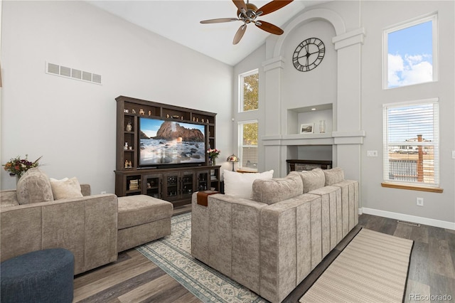 living room with dark wood-type flooring, ceiling fan, and high vaulted ceiling