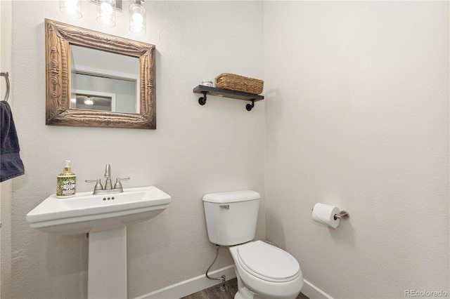 bathroom featuring sink, hardwood / wood-style flooring, and toilet