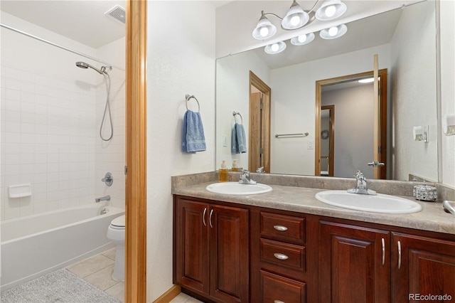 full bathroom with tile patterned flooring, vanity, tiled shower / bath combo, and toilet