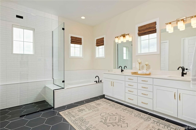 full bathroom featuring double vanity, tile patterned flooring, a sink, and a garden tub