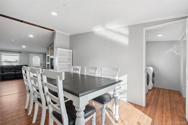 dining room with washing machine and clothes dryer, ornamental molding, and light wood-type flooring