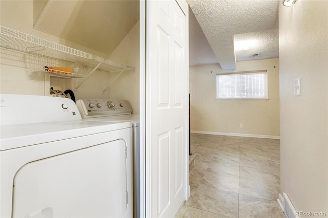 laundry room with washer and clothes dryer, visible vents, a textured ceiling, laundry area, and baseboards