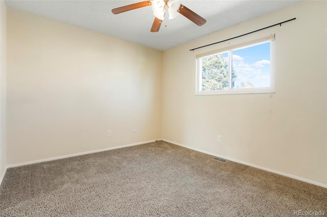 empty room with carpet floors, visible vents, a textured ceiling, and baseboards