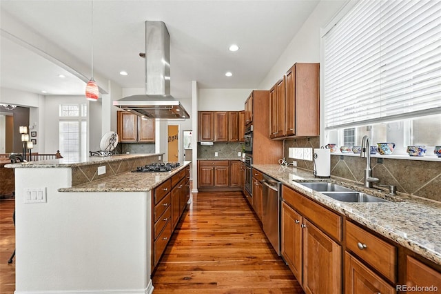 4944 W 107th Loop, Westminster, CO 80031 - kitchen featuring island range hood, stainless steel appliances, light wood finished floors, backsplash, and light stone countertops
