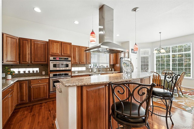 4944 W 107th Loop, Westminster, CO 80031 - kitchen with island range hood, dark wood-style floors, a center island, light stone countertops, and tasteful backsplash