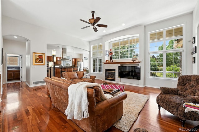 4944 W 107th Loop, Westminster, CO 80031 - living room featuring ceiling fan, arched walkways, wood finished floors, a glass covered fireplace, and recessed lighting