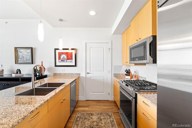2001 Lincoln St Unit 1723, Denver, CO 80202 - kitchen featuring stainless steel appliances, light wood-style floors, light brown cabinetry, tasteful backsplash, and light stone counters