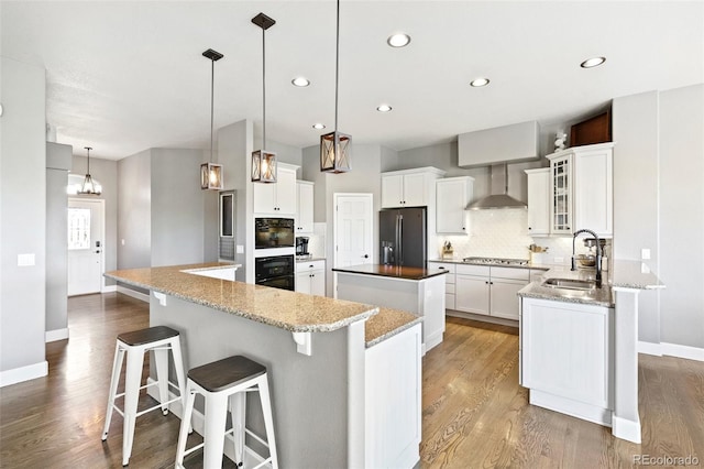 444 Pasada Way, Monument, CO 80132 - kitchen with a sink, refrigerator with ice dispenser, a kitchen island, wall chimney exhaust hood, and decorative backsplash