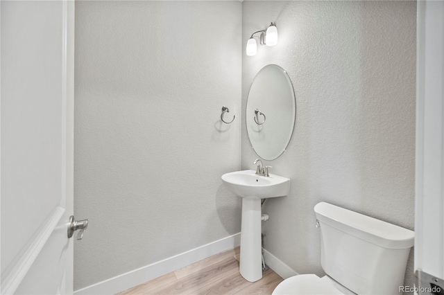 bathroom with hardwood / wood-style floors and toilet